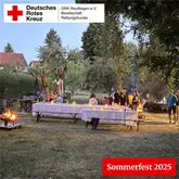 Setup mit Biertischen, Lagerfeuer und Kerzen in einem Garten zum Sommerfest der Rettungshunde Reutlingen 