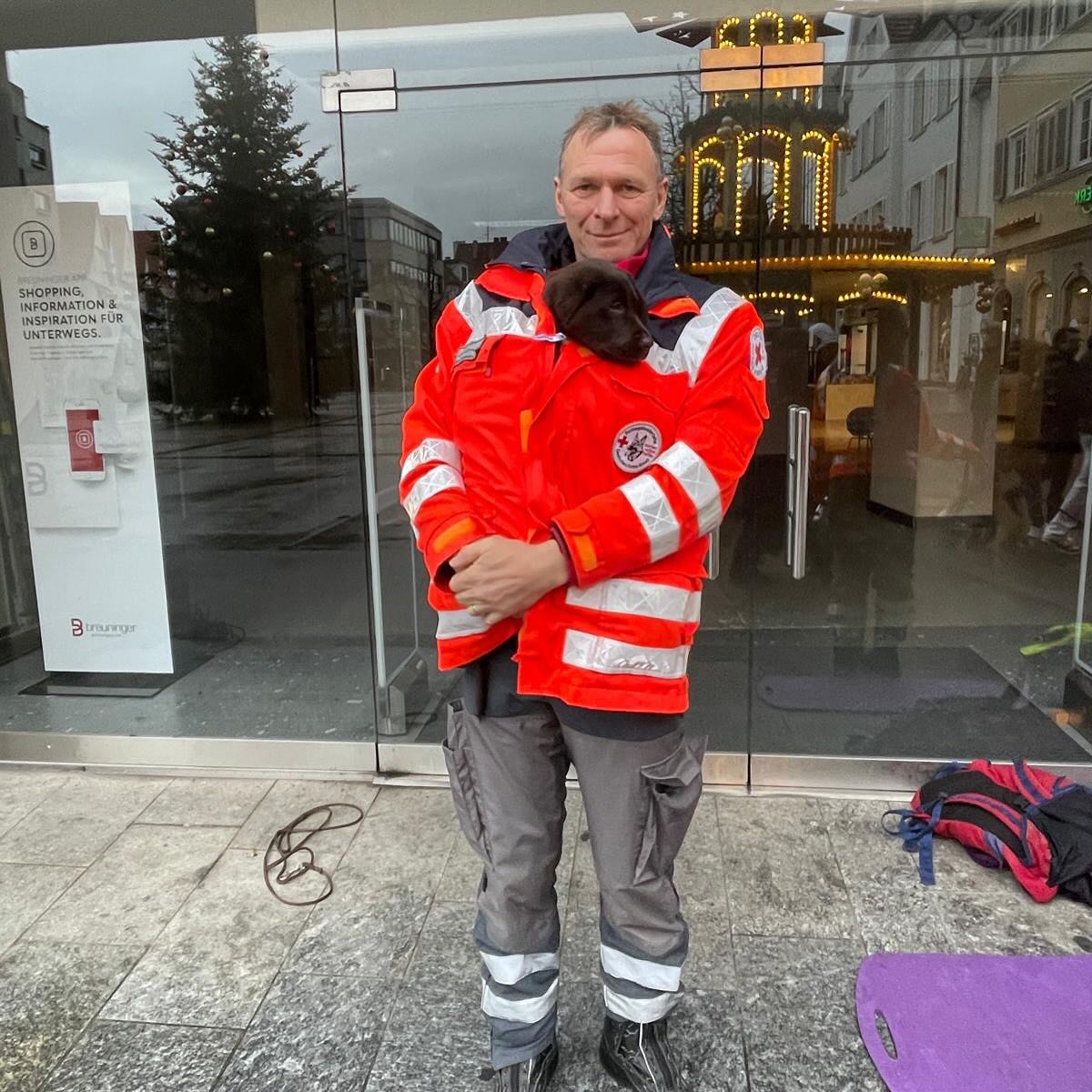 DRK Mitglied mit Welpe Rettungshunden beim weihnachtlichen Spenden sammeln