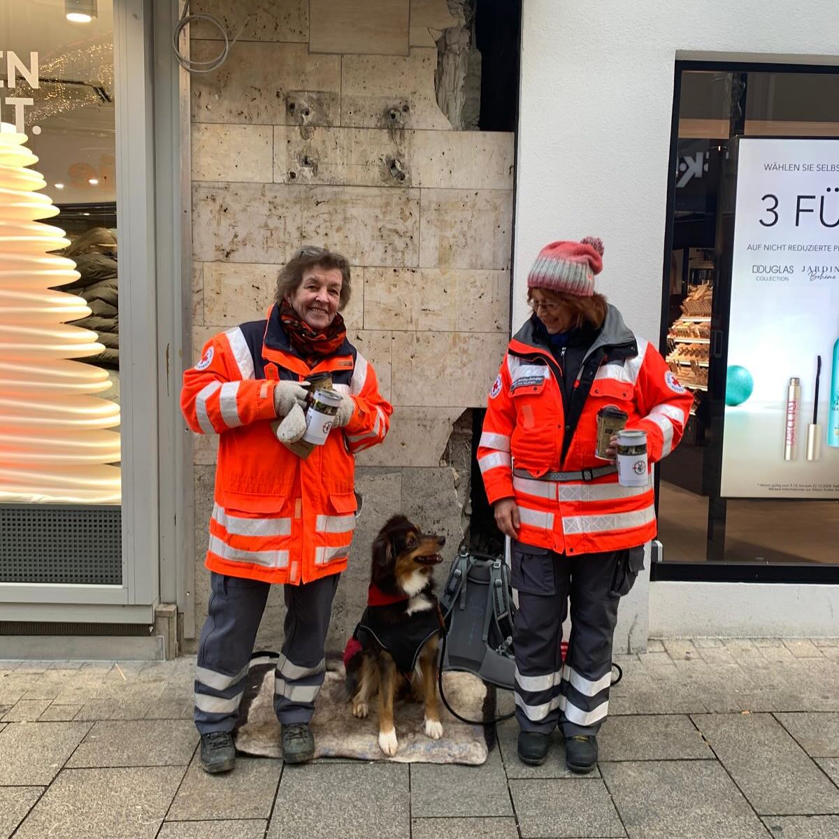 DRK Mitglied mit Rettungshund beim weihnachtlichen Spenden sammeln