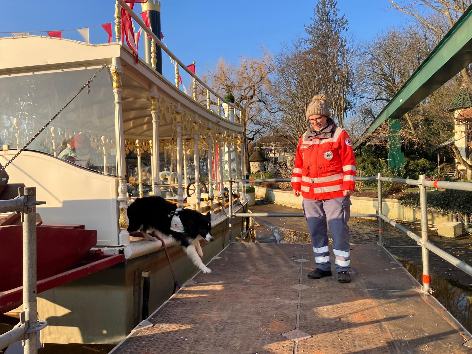 Ein Rettungshund springt aus einem Boot auf einen Steg im Europapark bei der Vermisstensuche.