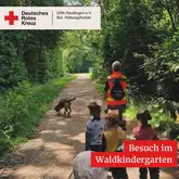 Besuch im Waldkindergarten 2025 Mantrailteam mit einer Gruppe Kindern auf einem Waldweg