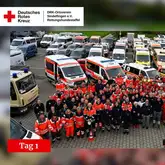 Einsatzübung Tag 1 2024 Parkpplatz mit vielen Einsatzfahrzeugen und Einsatzkräften der Rettungshunde, Feuerwehr und Sanitätern