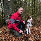 Rettungshundeteam im Wald beim Training zur Vermisstensuche