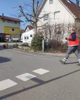 Mantrailhund mit Hundeführer auf einer Straße beim Trailen